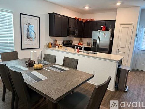 A kitchen with a table and chairs in front of it.
