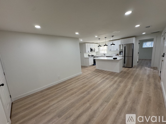 A spacious kitchen with a refrigerator, sink, and cabinets.
