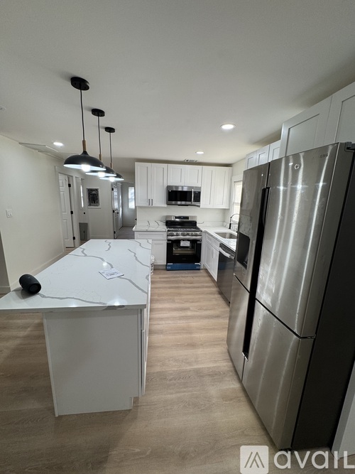 A modern kitchen with stainless steel appliances and a marble island.