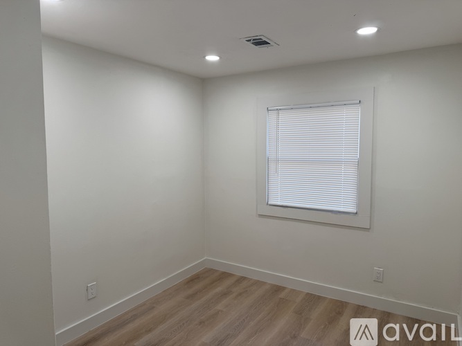 A room with a window and wooden flooring.