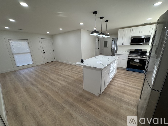 A kitchen with wooden floors and white walls.