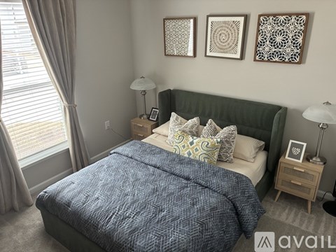 A bedroom with a bed, nightstands, and pictures on the wall.
