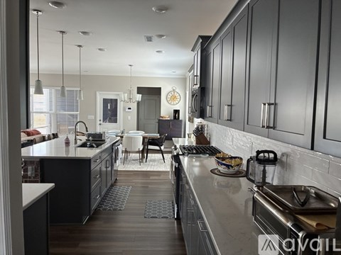 A modern kitchen with dark wood cabinets and a white countertop.