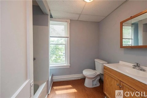A bathroom with a toilet, sink, and mirror.