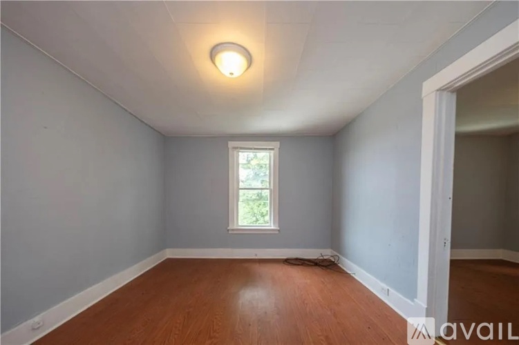 A room with a window and wooden flooring.