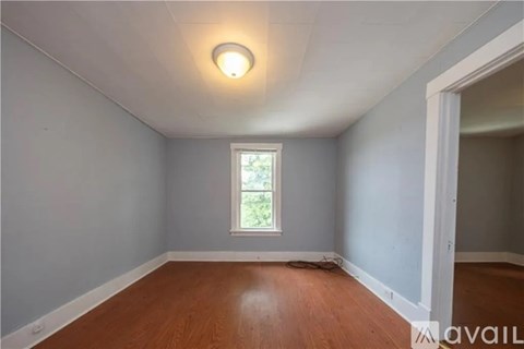 A room with a window and wooden flooring.