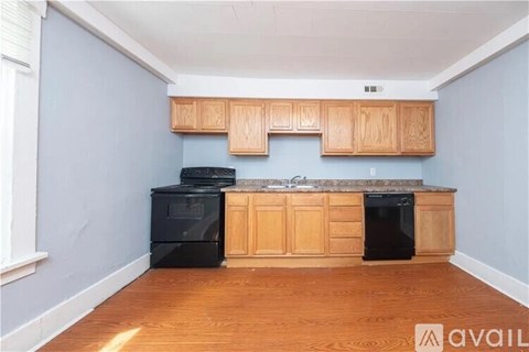 A kitchen with wooden cabinets and black appliances.