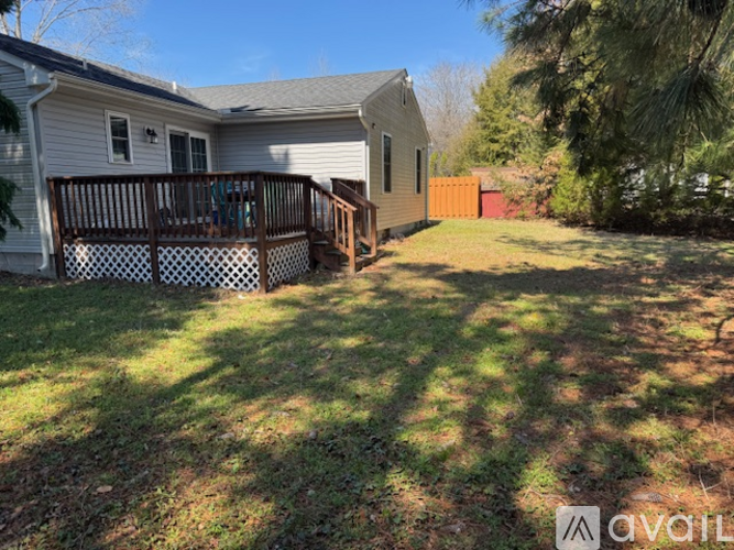 A house with a deck and a fence in the backyard.