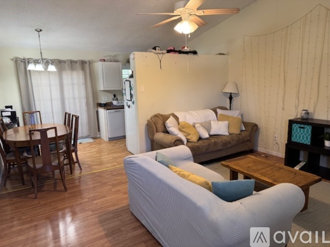 A living room with a couch, chairs, and a dining table.