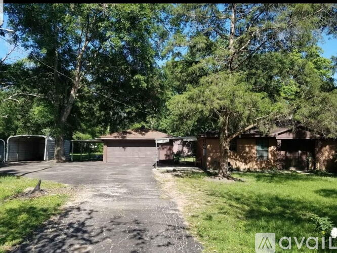 A house with a driveway surrounded by trees.