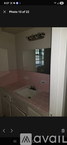 A bathroom with pink tiles and a white sink.