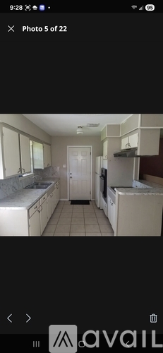 A kitchen with white cabinets and a tiled floor.