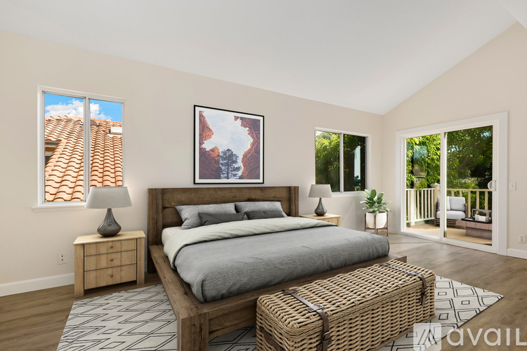 A bedroom with a large bed, a wooden nightstand, and a painting on the wall.
