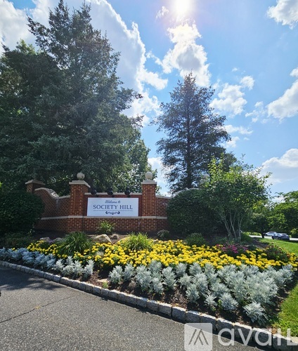 A sign that says "Society Hill" is in front of some trees.