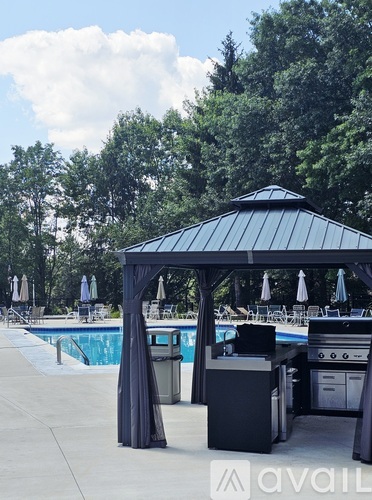 A poolside area with a gazebo and a grill.