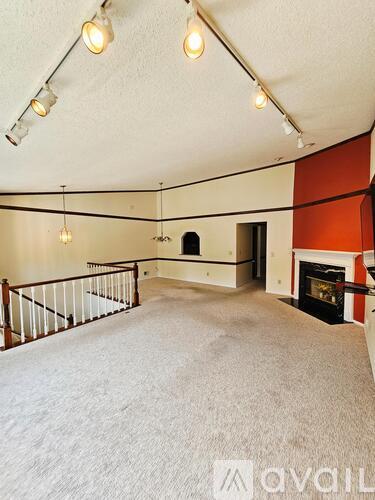 A living room with a fireplace and a staircase.