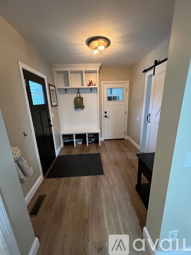 A hallway with a black mat on the floor and a light on the ceiling.