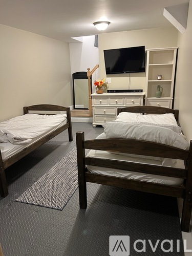 A bedroom with two beds and a television.