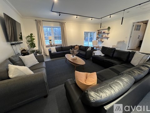 A living room with black leather couches and a wooden coffee table.
