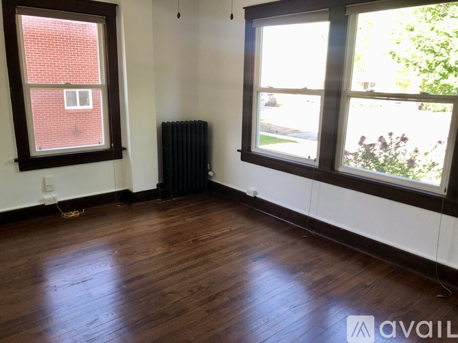 A room with a wood floor and two windows.
