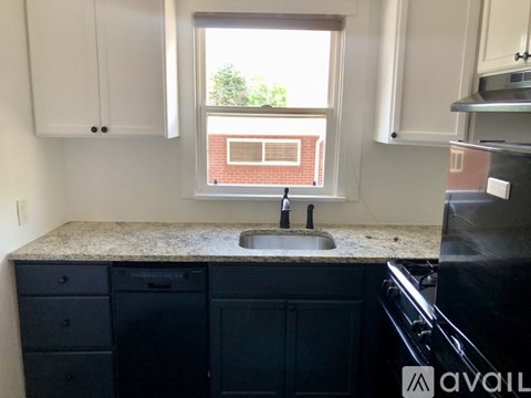 A kitchen with black cabinets and a granite countertop.