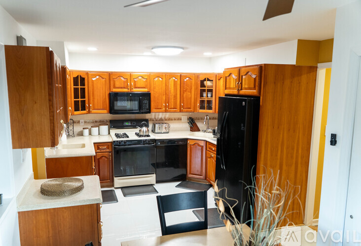 A kitchen with wooden cabinets and black appliances.