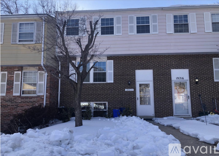 A house with a tree in front of it and snow on the ground.
