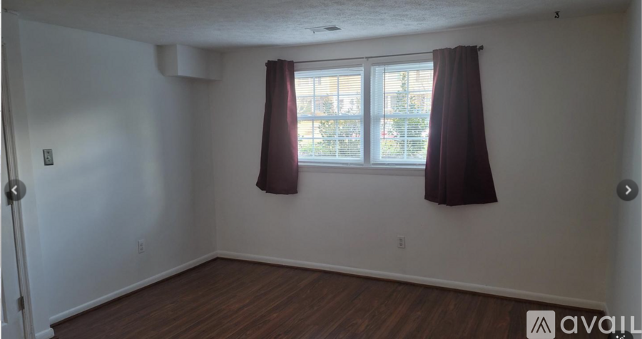 A room with a window and a brown curtain.