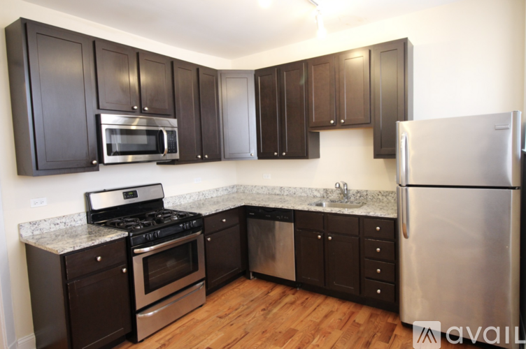 A kitchen with dark brown cabinets and stainless steel appliances.