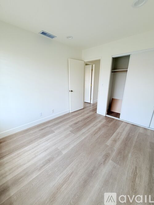 A room with a wooden floor and a white wall.