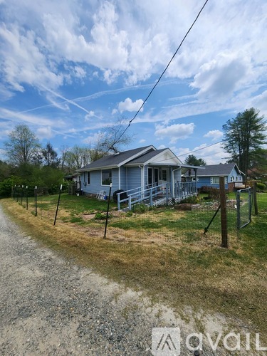A house with a blue roof and a sign that says "avail" in front of it.