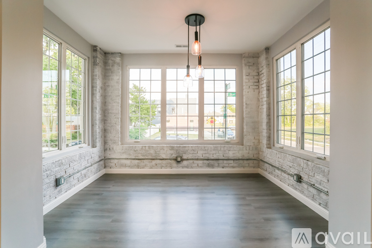 A room with a large window and a hanging light fixture.