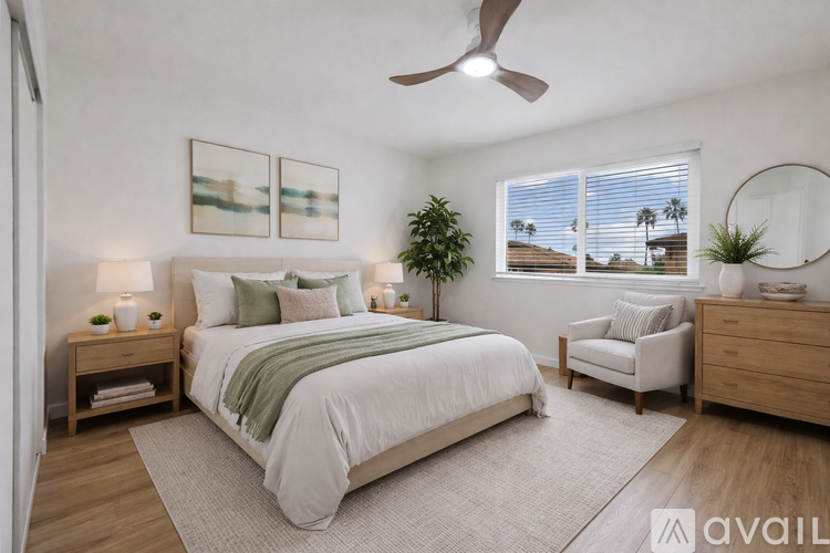A bedroom with a large bed, a ceiling fan, and a view of the outdoors through the window.