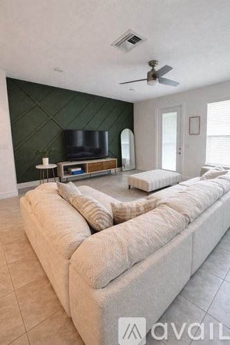 A living room with a long couch and a flat screen TV.