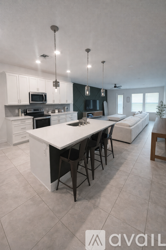 A modern kitchen with a large island and a dining area.