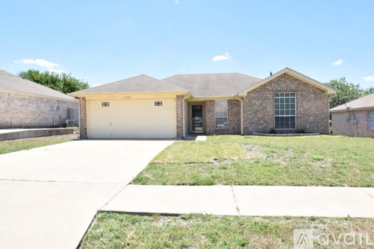 A house with a garage and a driveway in front.