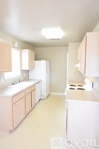 A kitchen with white appliances and cabinets.