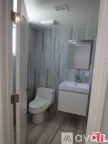 A white toilet and sink in a bathroom.