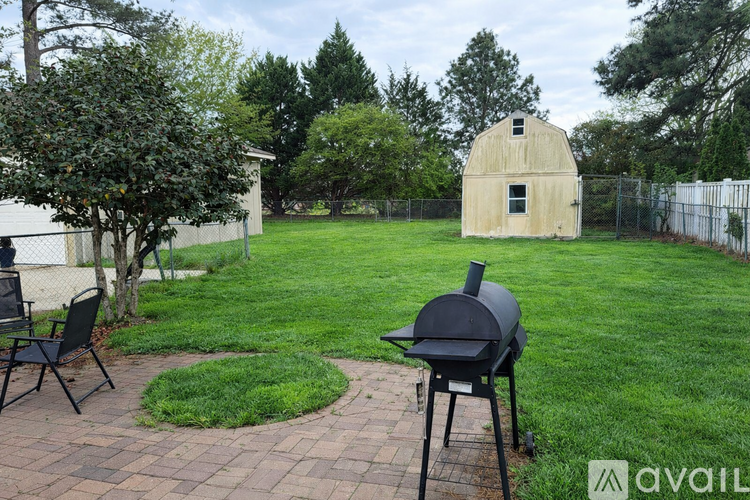 A backyard with a grill and a chair.