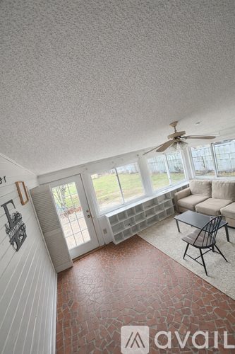 A living room with a couch, chair, and a ceiling fan.