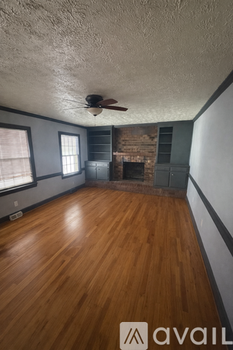 A room with wooden floors and a ceiling fan.