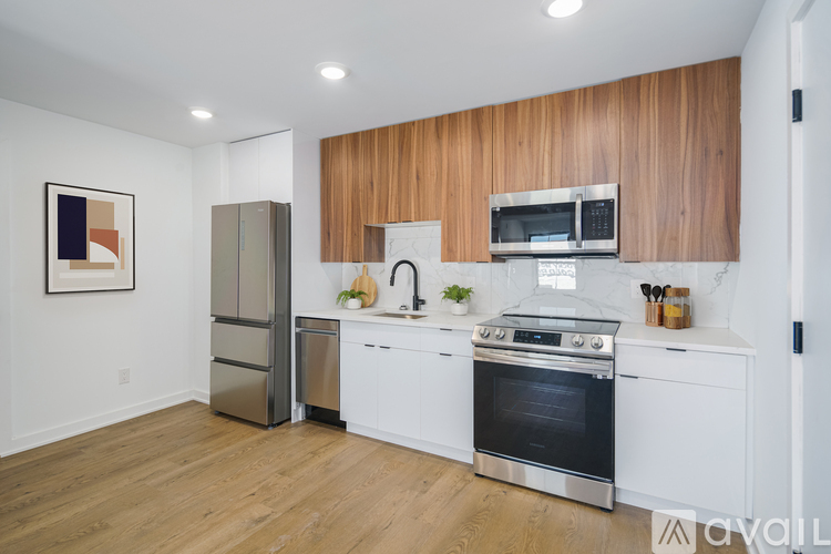 A kitchen with white cabinets and a wooden backsplash.