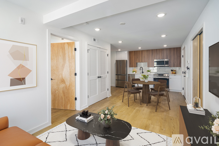 A modern living room with a dining area and kitchen in the background.