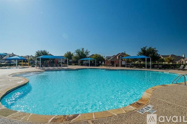 A large outdoor swimming pool with a sunny sky above.