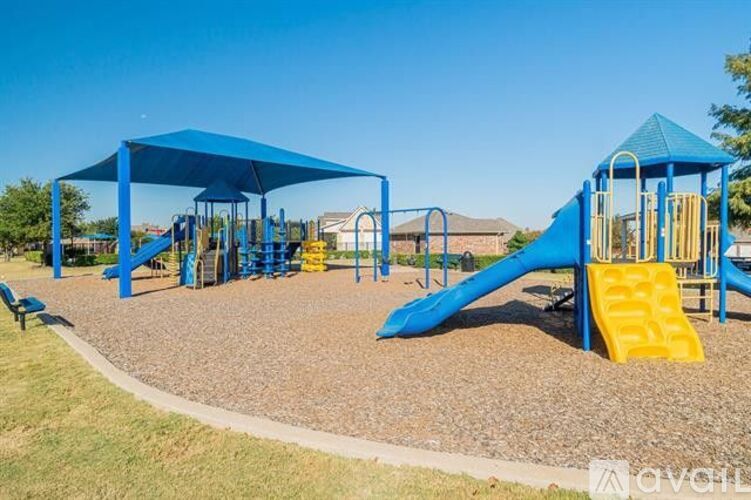 A playground with a blue slide and a yellow slide.