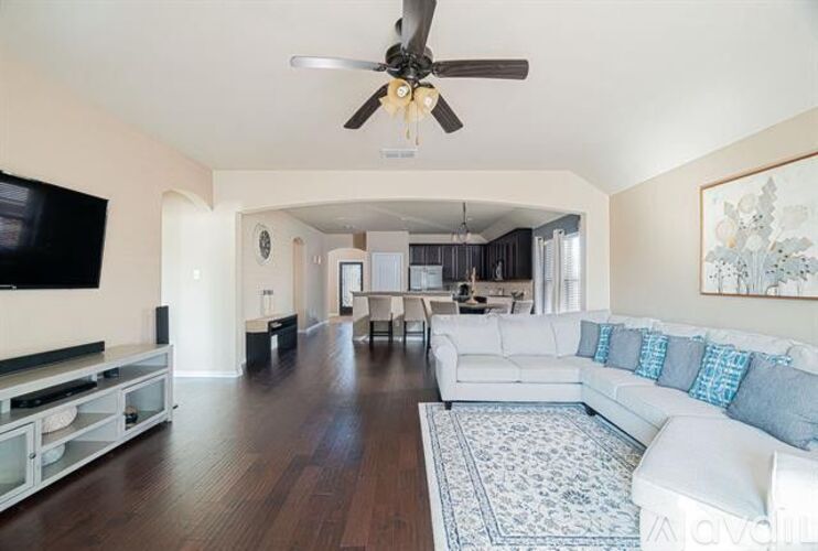 A living room with a white couch and a ceiling fan.