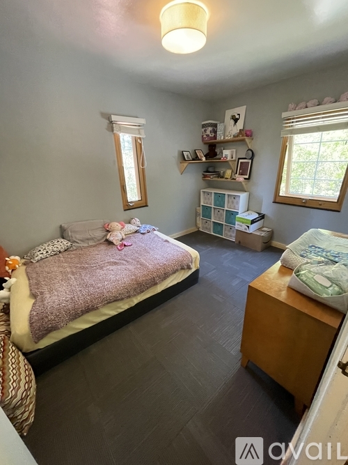 A bedroom with a bed, a dresser, and a window.