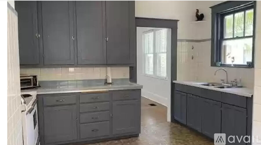 A kitchen with grey cabinets and a washing machine.