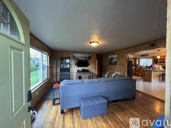 A living room with a grey couch and a wooden floor.