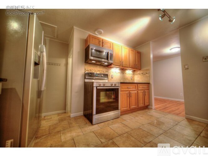 A kitchen with a refrigerator, microwave, oven, and cabinets.